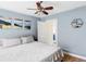A blue bedroom features artwork, a ceiling fan, and an open door to another room at 3365 S Grant St, Englewood, CO 80113