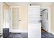 A laundry area includes a stackable washer and dryer and a door leading to another room at 3365 S Grant St, Englewood, CO 80113