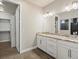 A bathroom with granite counters, double sinks, updated fixtures, tile floor, and open doorway at 4837 S Buchanan St, Aurora, CO 80016