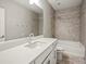 Well-lit bathroom featuring white cabinets, dual sinks, quartz countertops, and a tub-shower combo at 4837 S Buchanan St, Aurora, CO 80016