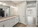 Bathroom featuring double sinks, granite countertop, tile floors, and an open doorway at 4837 S Buchanan St, Aurora, CO 80016