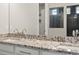 Bathroom featuring a granite countertop, double sinks, and an open doorway at 4837 S Buchanan St, Aurora, CO 80016
