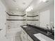 Bathroom with white marble tiled walls, dual sinks with granite countertops, and modern fixtures at 4837 S Buchanan St, Aurora, CO 80016