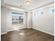 Sunlit bedroom featuring hardwood floors, tray ceiling, and large window overlooking the street at 4837 S Buchanan St, Aurora, CO 80016