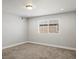 Neutral carpeted bedroom with one window, overhead light, and white walls at 4837 S Buchanan St, Aurora, CO 80016