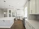 Modern kitchen boasts stainless steel appliances, a spacious island with quartz countertops and white cabinetry at 4837 S Buchanan St, Aurora, CO 80016