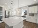 Bright kitchen featuring white cabinets, stainless steel appliances, and a large island with hardwood floors at 4837 S Buchanan St, Aurora, CO 80016