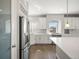 Well-lit kitchen features stainless steel appliances, tile backsplash, and sleek white cabinets for ample storage at 4837 S Buchanan St, Aurora, CO 80016