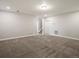 Spacious, carpeted living room with natural paint and paneled door to hallway with staircase at 4837 S Buchanan St, Aurora, CO 80016