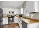 Bright kitchen featuring white cabinets, stainless steel appliances, and wood-style countertops at 3853 S Genoa Ct # D, Aurora, CO 80013