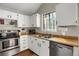 Bright kitchen featuring white cabinets, stainless steel appliances, and wood-style countertops at 3853 S Genoa Ct # D, Aurora, CO 80013