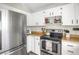Well-lit kitchen boasting stainless steel appliances, white cabinets, and wood-style countertops at 3853 S Genoa Ct # D, Aurora, CO 80013