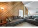 Spacious living room with vaulted ceiling, wood-paneled wall, and comfortable gray sofas at 3853 S Genoa Ct # D, Aurora, CO 80013