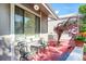 Cozy red-toned porch featuring metal chairs and table with a view of outdoor plants at 3853 S Genoa Ct # D, Aurora, CO 80013