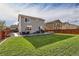Backyard view showcasing grassy lawn, patio, and privacy fence at 16048 Elizabeth St, Thornton, CO 80602