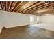 Unfinished basement with exposed ceiling and black painted flooring at 16048 Elizabeth St, Thornton, CO 80602