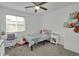 Bright bedroom with plush carpet, ceiling fan, and a window overlooking the backyard at 16048 Elizabeth St, Thornton, CO 80602