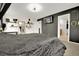 This bedroom features dark walls, carpet, decorative shelving, and a TV mounted on the wall at 16048 Elizabeth St, Thornton, CO 80602