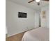 This bedroom features neutral walls, carpet, a ceiling fan, and a TV mounted on the wall at 16048 Elizabeth St, Thornton, CO 80602