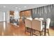 Open-concept dining room with hardwood floors, island kitchen, designer lighting, and seating for eight at 16048 Elizabeth St, Thornton, CO 80602