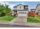 Charming gray two-story home with a manicured lawn and a two-car garage at 16048 Elizabeth St, Thornton, CO 80602