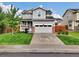 Charming gray two-story home with a manicured lawn and a two-car garage at 16048 Elizabeth St, Thornton, CO 80602