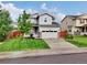 Charming gray two-story home with a manicured lawn and a two-car garage at 16048 Elizabeth St, Thornton, CO 80602