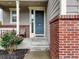 Inviting front porch featuring brick accents and a stylish gray front door at 16048 Elizabeth St, Thornton, CO 80602