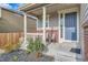 Inviting front porch with chairs, decorative columns and brick accents at 16048 Elizabeth St, Thornton, CO 80602