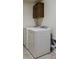 Bright laundry room boasts white appliances and cabinet storage at 16048 Elizabeth St, Thornton, CO 80602