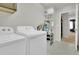 Well-equipped laundry room with modern appliances and plenty of shelving for storage at 16048 Elizabeth St, Thornton, CO 80602