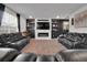Living room with black accent wall, electric fireplace, and modern leather recliners at 16048 Elizabeth St, Thornton, CO 80602