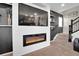Modern living room featuring a built-in fireplace and a staircase at 16048 Elizabeth St, Thornton, CO 80602