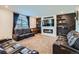 Modern living room with comfortable leather seating, entertainment center and cozy fireplace at 16048 Elizabeth St, Thornton, CO 80602