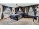 Elegant main bedroom with dark accent wall, canopy bed, and ample natural light at 16048 Elizabeth St, Thornton, CO 80602