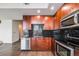 Updated kitchen featuring wood cabinets, stainless appliances, black countertops, and black tiled backsplash at 1700 Bassett St # 802, Denver, CO 80202