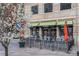 Exterior of a restaurant with outdoor seating, flowering tree, and awning with black trim at 1700 Bassett St # 802, Denver, CO 80202