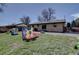 Backyard with grass, patio, home exterior, and colorful play equipment at 1641 Orchard Dr, Denver, CO 80221