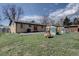 Open backyard with grass, patio, brick home, and outdoor toys at 1641 Orchard Dr, Denver, CO 80221