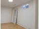 Bright basement featuring wood flooring, white trim, and a window providing natural light at 1641 Orchard Dr, Denver, CO 80221