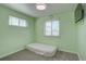 Fresh green bedroom showcasing plenty of natural light and neutral carpet and perfect for relaxing or reading at 1641 Orchard Dr, Denver, CO 80221