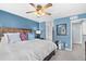 Comfortable bedroom features blue walls, ceiling fan, wood trim bed frame and decorative pillows at 14300 Waterside Ln # J4, Broomfield, CO 80023