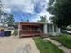 Charming single-story home with a brick facade, red porch, and sunny sky above at 888 Wolff St, Denver, CO 80204