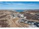 Aerial view of a residential neighborhood by a lake, highlighting community layout and scenic surroundings at 7517 Copper Sky Ct, Castle Pines, CO 80108
