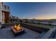 Cozy backyard featuring a modern fire pit and seating area, perfect for outdoor entertaining in the evening at 7517 Copper Sky Ct, Castle Pines, CO 80108