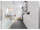 Luxurious bathroom featuring dual shower heads, glass enclosure and white tile, complemented by black mosaic flooring at 7517 Copper Sky Ct, Castle Pines, CO 80108
