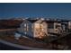 Stunning exterior view of a modern home with large windows, a backyard fire pit, and well-kept landscaping at 7517 Copper Sky Ct, Castle Pines, CO 80108
