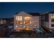 Stunning home exterior with a fire pit, hot tubs, and a beautifully landscaped yard at night at 7517 Copper Sky Ct, Castle Pines, CO 80108