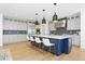 Modern kitchen boasts an island with seating, stainless steel appliances, and stylish pendant lighting at 7517 Copper Sky Ct, Castle Pines, CO 80108