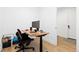 Home office space featuring a modern adjustable desk and doorway at 7517 Copper Sky Ct, Castle Pines, CO 80108